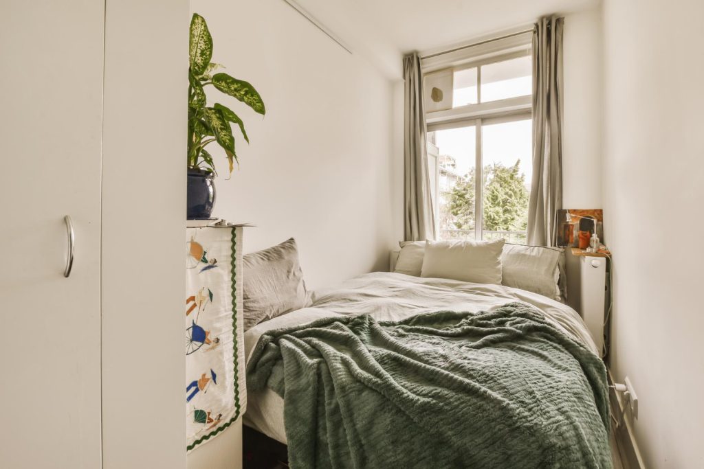 Mała sypialnia z szafą i przytulnymi tekstyliami